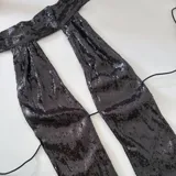 Top negro de lentejuelas con tiras finas para atar en la espalda.