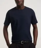 Remera slim de manga corta color salmón, de punto medio, sin estampado y cuello redondo.