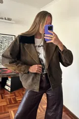 Campera bomber marrón de cuero ovino vintage, con cuello de piel sintética negra desmontable y cierre frontal con cremallera.