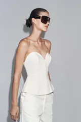 Bustier blanco de denim con escote corazón y hombros descubiertos.