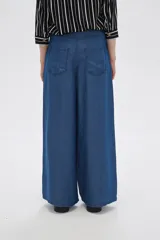 Pantalón de lyocell azul con bolsillos, corte holgado y de calce alto.