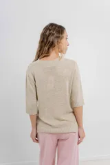 Buzo de punto abierto color beige, de corte oversize, con mangas 3/4 y terminaciones acanaladas.