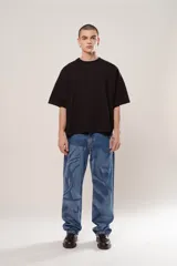 Pantalón de denim azul con diseño abstracto en tono más claro, de corte wide leg y cinco bolsillos.