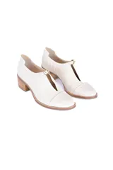 Zapato de cuero texturizado color blanco hueso, con punta cuadrada, detalle de hebilla dorada y taco de madera.