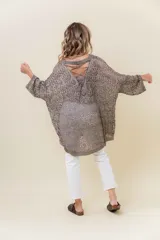 Buzo tejido liviano color bronce/marrón con diseño calado y textura sutilmente brillante. Presenta un calce amplio y mangas amplias, con detalle de tiras entrecruzadas en la espalda.