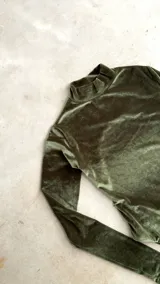 Body de terciopelo marrón con estampado de piel de serpiente, cuello alto, mangas largas con orificio para el pulgar y espalda descubierta.