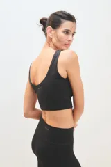 Top deportivo negro con breteles anchos y espalda deportiva.