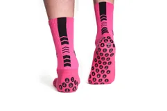 Medias deportivas largas color rosa con detalles en negro y suela antideslizante.