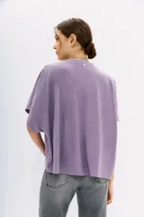 Remera lila con estampado de cachemir, de mangas cortas y cuello redondo. Tiene calce amplio y corte cruzado al frente.