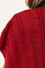 Ruana tejida de hilo color rojo con lurex y terminación de flecos.