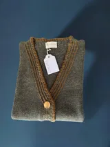 Chaleco tejido a mano con escote en V, bordado con botones, confeccionado en algodón con detalles de lurex. Terminaciones en crochet y bordados hechos a mano con lana merino.