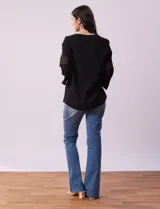 Blusa negra de gasa bambula con cuello a la base y escote en V. Tiene mangas 3/4 amplias con apliques de crochet.