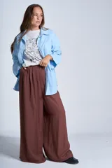 Sobrecamisa negra de gabardina con cuello camisero, cierre frontal con botones, mangas largas con puños abotonados y bolsillos de parche en el pecho.