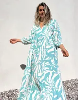 Vestido largo de corte amplio, con estampado abstracto en tonos verde agua y crudo. Tiene escote en V con lazos y mangas largas abullonadas.