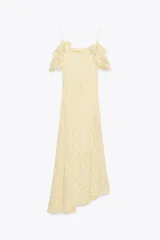 Vestido midi color crema confeccionado en encaje, con escote recto, tirantes finos, volantes y tachas.