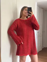 Vestido corto tejido en algodón y lurex color crudo, con punto pavo real, manga larga y escote en la espalda.