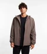 Campera rompevientos color verde oliva, con capucha ajustable con cordón, cierre frontal con cremallera, bolsillos laterales con cremallera y puños elásticos.