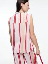 Chaleco con estampado a rayas verticales rojas, beige y blancas, con cuello en V, cierre frontal con botones y bolsillos delanteros.