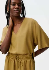 Blusa color crema con escote en V y mangas cortas amplias.