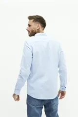 Camisa de lino color beige, de manga larga, corte semi slim y logo bordado en el pecho.
