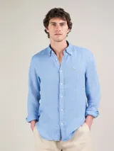 Camisa celeste de lino, de corte regular fit, cuello italiano, cierre con botones, manga larga terminada en puño simple y logo bordado en el pecho.