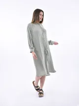 Vestido camisero midi a rayas verticales grises y blancas, con cuello mao y mangas largas abullonadas.