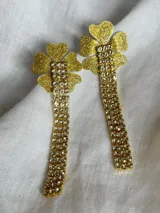 Aros colgantes dorados con forma de flor y tiras de strass. Cierre con enganche de acero quirúrgico y tapón de goma.