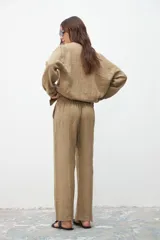 Pantalón caqui de corte recto y tiro alto, con bolsillos laterales y pinzas en la cintura.