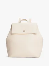 Mochila Tommy Hilfiger color crema con cierre de solapa magnético, asa superior y dos correas ajustables. Tiene un compartimento principal y un bolsillo interior con cremallera.