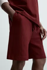 Bermuda negra de corte relaxed fit, con cintura elástica ajustable con cordón, bolsillos frontales y bolsillo trasero de parche.