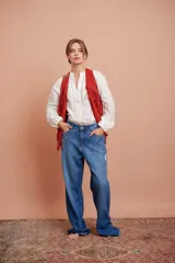 Blusa blanca de cuello Mao y manga larga con detalle de vainilla en la abertura frontal.