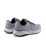 Championes de trail running New Balance Dynasoft Nitrel V5, color gris con detalles en azul y suela con patrón de puntos.