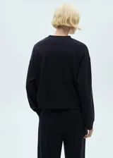 Sweater negro de corte estándar, cuello redondo y manga larga.