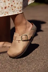 Zueco color tostado con hebilla dorada ajustable, plantilla anatómica y suela de goma.