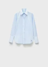 Camisa celeste de popelina de algodón y lyocell, de corte oversize, manga larga con puños abotonados, cuello camisero y cierre frontal con botones.