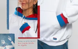 Canguro blanco con capucha forrada en azul y puños en rojo y azul. Diseño holgado con bolsillo delantero tipo canguro.