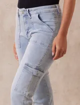 Pantalón jean celeste con bolsillos cargo laterales, pretina con pasadores, botón y cierre.