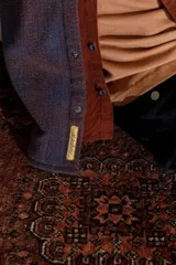 Camisa de franela escocesa con cuello, cierre frontal con botones, dos bolsillos con solapa abotonada en el pecho y corte recto.