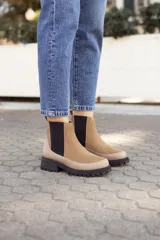 Botas Chelsea de cuero color beige con elástico negro en los laterales y suela track negra.