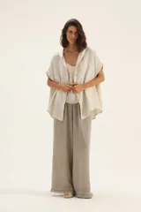 Pantalón de lino color beige, de corte palazzo y terminación con flecos.