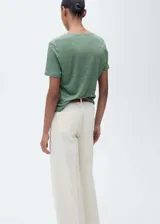 Remera color crema de lino con cuello en V y mangas cortas.