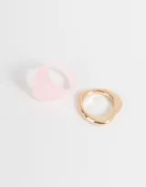 Set de dos anillos, uno dorado con forma irregular y otro rosado con forma cuadrada.