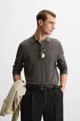 Polo de hombre color gris oscuro, de punto ligero tejido en hilatura con mezcla de seda y algodón. Tiene cuello solapa con cierre frontal de botonadura, manga larga y acabados en rib.
