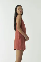 Mono corto estilo jardinero color ladrillo, con breteles regulables y hebillas metálicas.