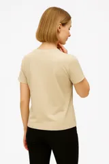 Remera negra de algodón con cuello en V y estampado frontal con la frase "Never Stop Me" en letras doradas y plateadas con estrellas.