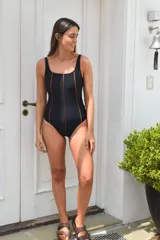 Traje de baño entero negro con breteles anchos y costuras laterales en color cobre.
