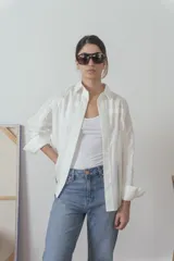 Camisa blanca de manga larga con cuello clásico y cierre frontal con botones.