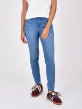 Jean de mujer, tiro medio-alto, color azul claro con lavado uniforme. Corte ajustado tipo skinny o slim fit.