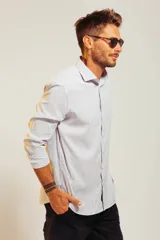 Camisa blanca de vestir con finas rayas verticales celestes, de corte clásico y manga larga.