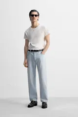 Pantalón de jean gris de corte recto, con cinco bolsillos, efecto lavado y cierre frontal con botones.